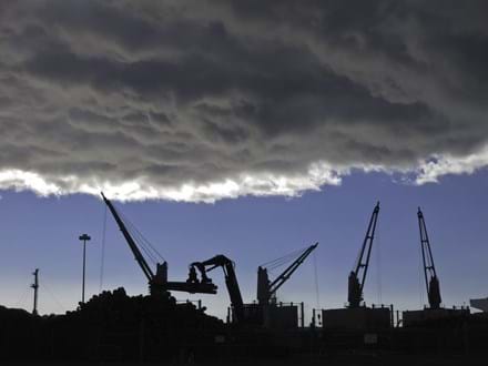 Storm cloud over silhouettes of cranes lifting logs to be shipped from seaport of Astoria, Oregon-2.jpeg